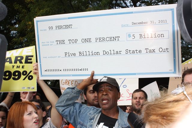 A protester displays the amount of money that will be lost in tax revenue if the Millionaire's Tax isn't renewed